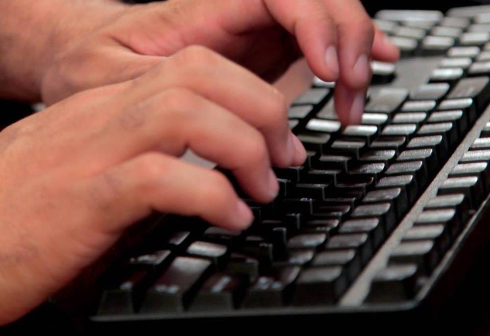 Hands typing on a keyboard.